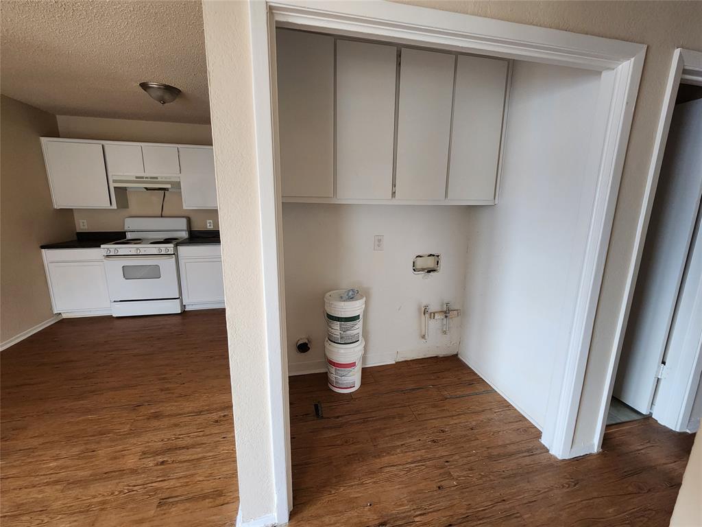 4304 South Cravens Road Fort Worth, TX 76119 - Photo 15 of 21 Laundry area featuring dark hardwood / wood-style flooring and a textured ceiling