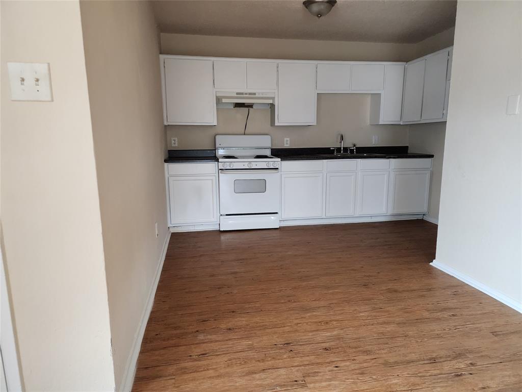 4304 South Cravens Road Fort Worth, TX 76119 - Photo 8 of 21 Kitchen featuring white cabinetry, sink, wood-type flooring, and white range with electric stovetop