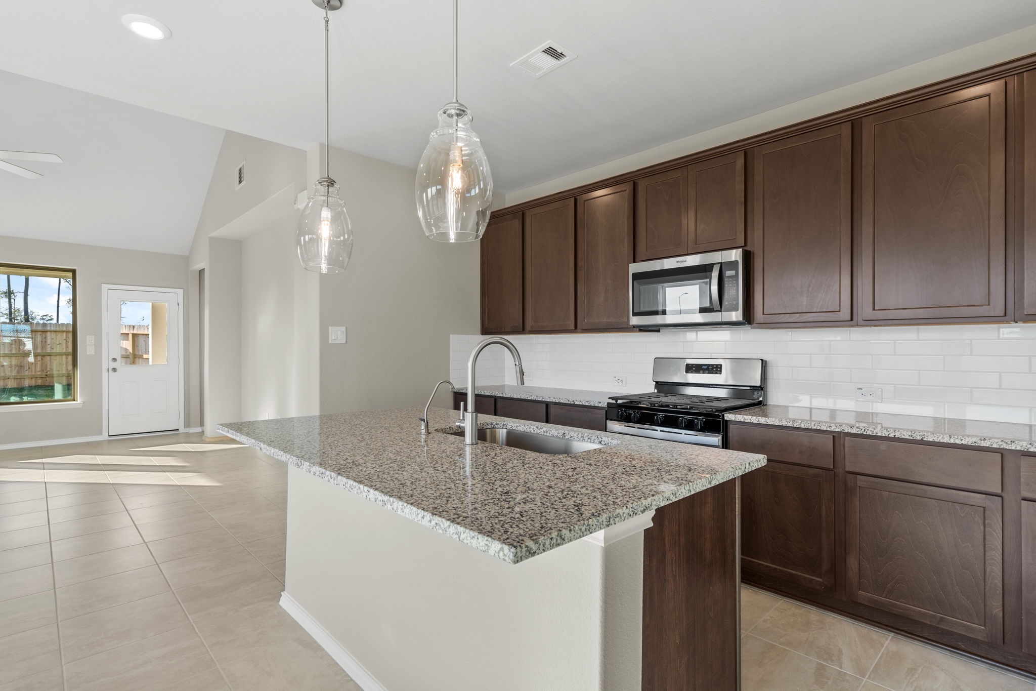32027 Retama Rnch Drive Spring, TX 77386 - Photo 5 of 33 a kitchen with kitchen island granite countertop a sink appliances and cabinets