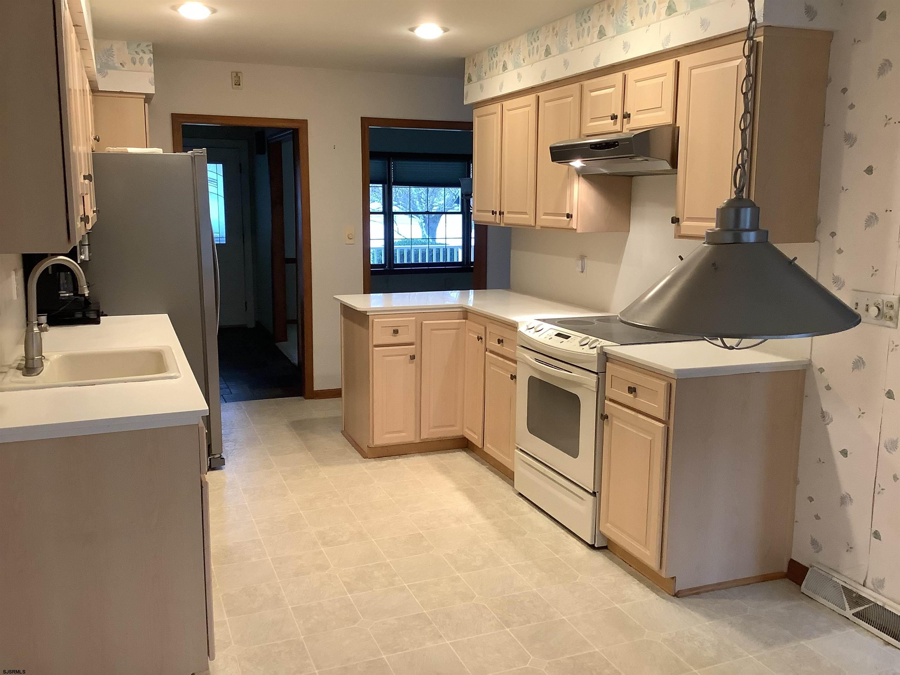 145 Allendale Road Marmora, NJ 08223 - Photo 19 of 27 a kitchen with stainless steel appliances a stove a refrigerator a sink and white cabinets