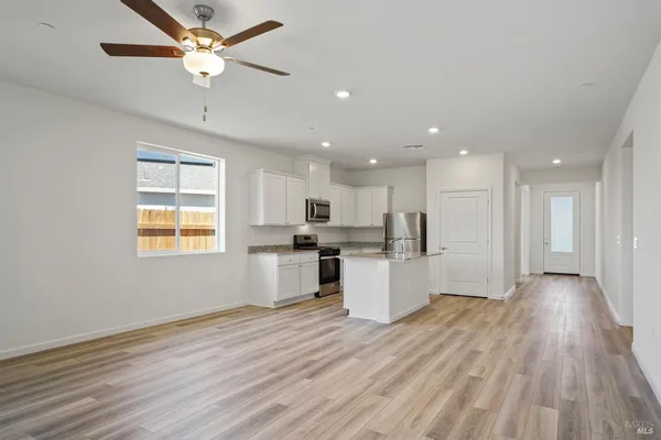 a view of kitchen with stainless steel appliances refrigerator stove microwave and cabinets