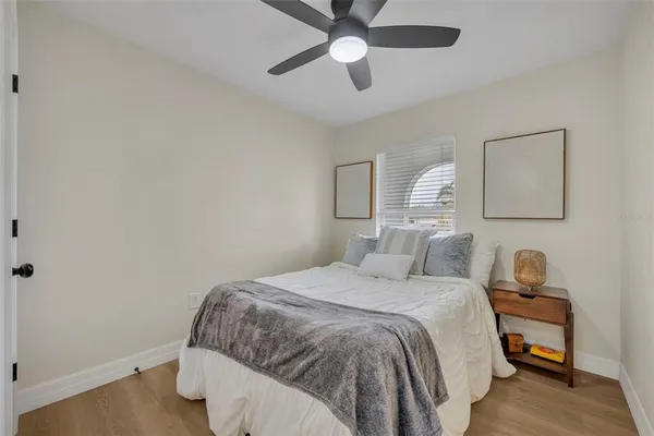 a bedroom with a bed and wooden floor
