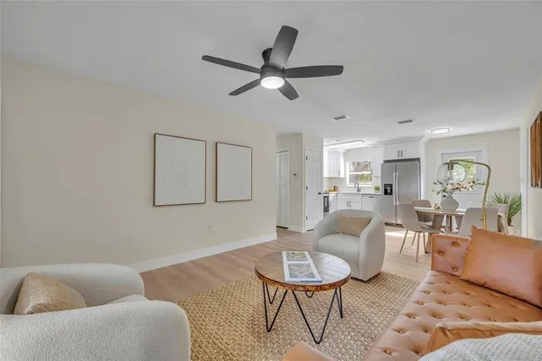 a living room with furniture and a view of kitchen
