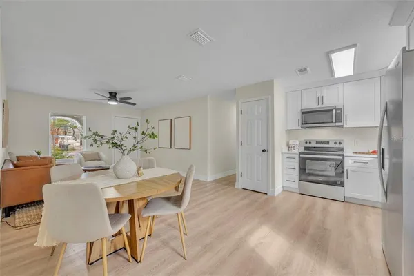 a kitchen with kitchen island white cabinets and stainless steel appliances