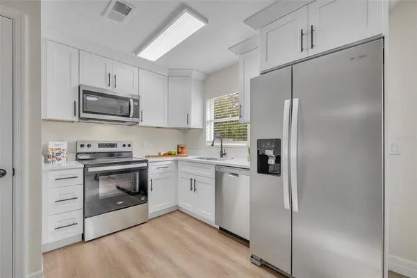 a kitchen with stainless steel appliances a refrigerator sink and microwave