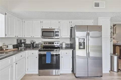 a kitchen with stainless steel appliances a refrigerator and a stove top oven