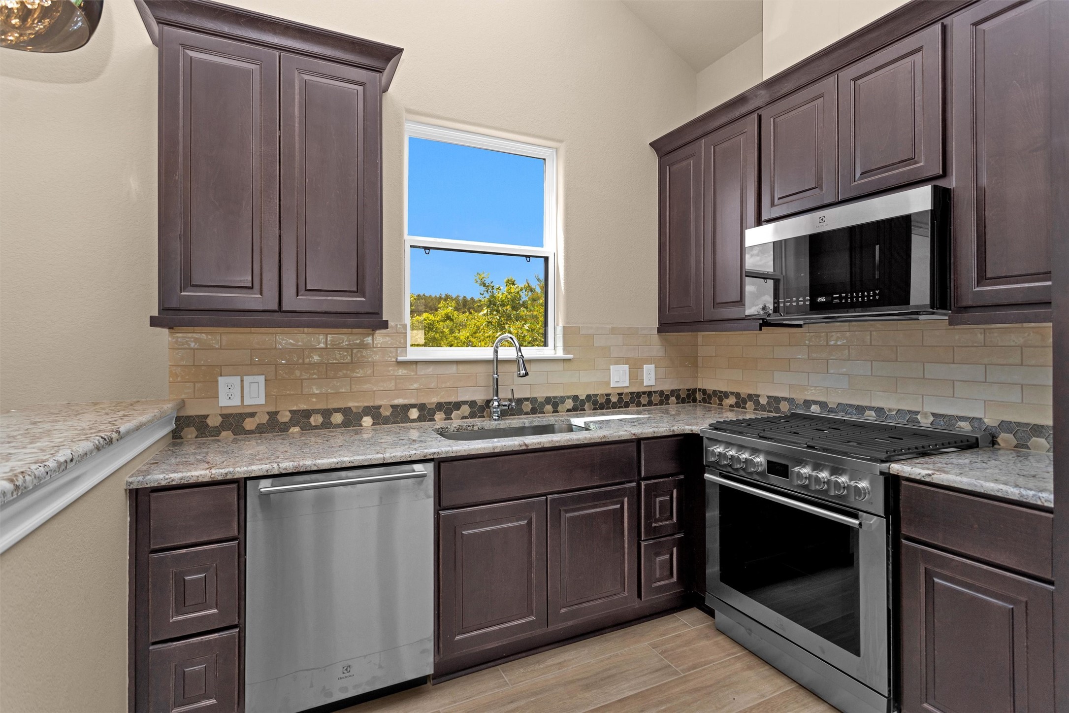 16081 Forest Mill Road Willis, TX 77378 - Photo 31 of 39 a kitchen with stainless steel appliances granite countertop wooden cabinets stove top oven and sink