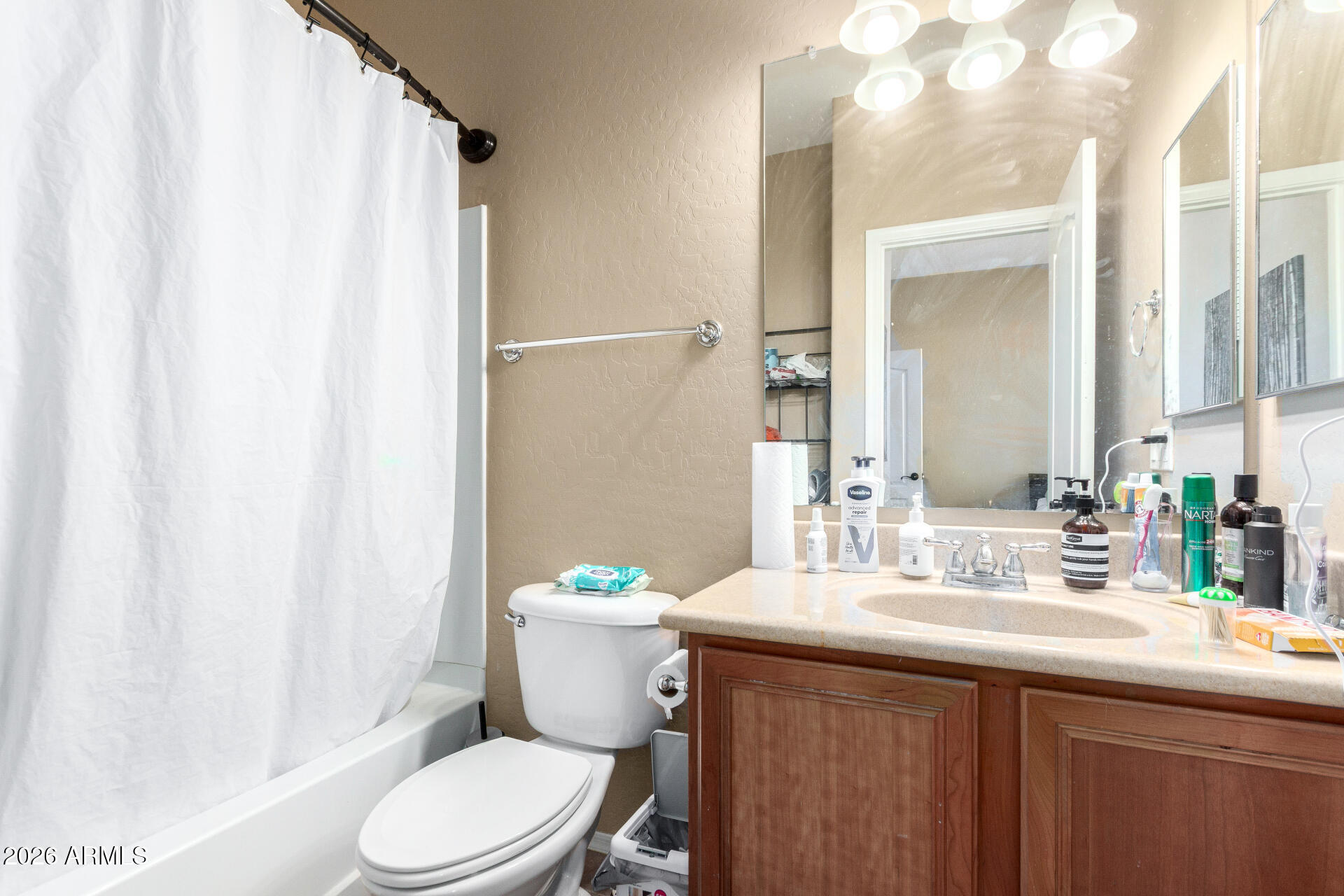 2257 East Huntington Drive Phoenix, AZ 85040 - Photo 18 of 25 a bathroom with a sink a toilet a mirror and shower curtain