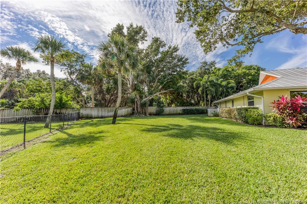 4 Michael Road Sewall's Point, FL 34996 - Photo 6 of 28 a view of a house with a big yard and palm trees