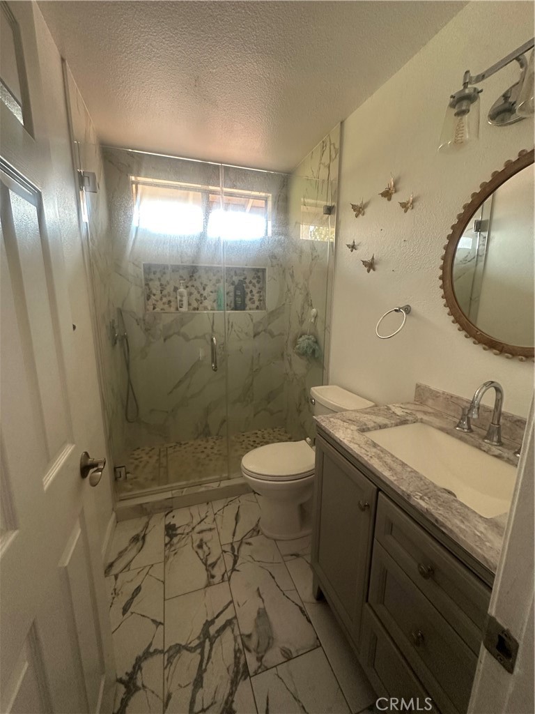 5147 Moonraker Road Palmdale, CA 93552 - Photo 15 of 21 a bathroom with a granite countertop sink toilet a mirror and shower