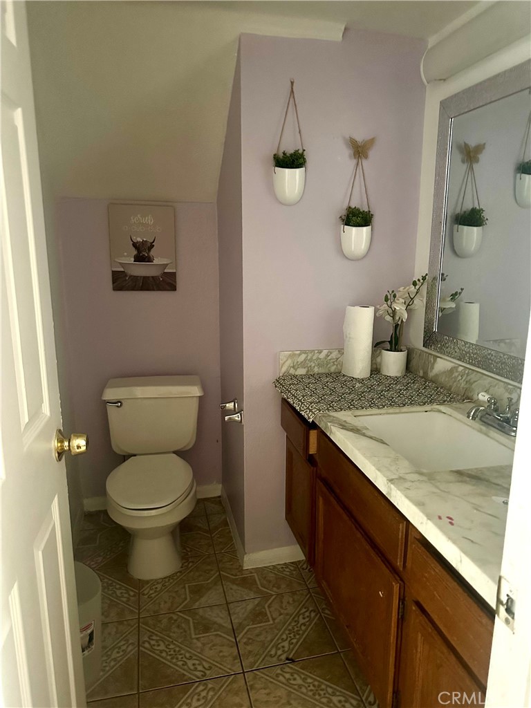 5147 Moonraker Road Palmdale, CA 93552 - Photo 9 of 21 a bathroom with a granite countertop toilet sink and mirror
