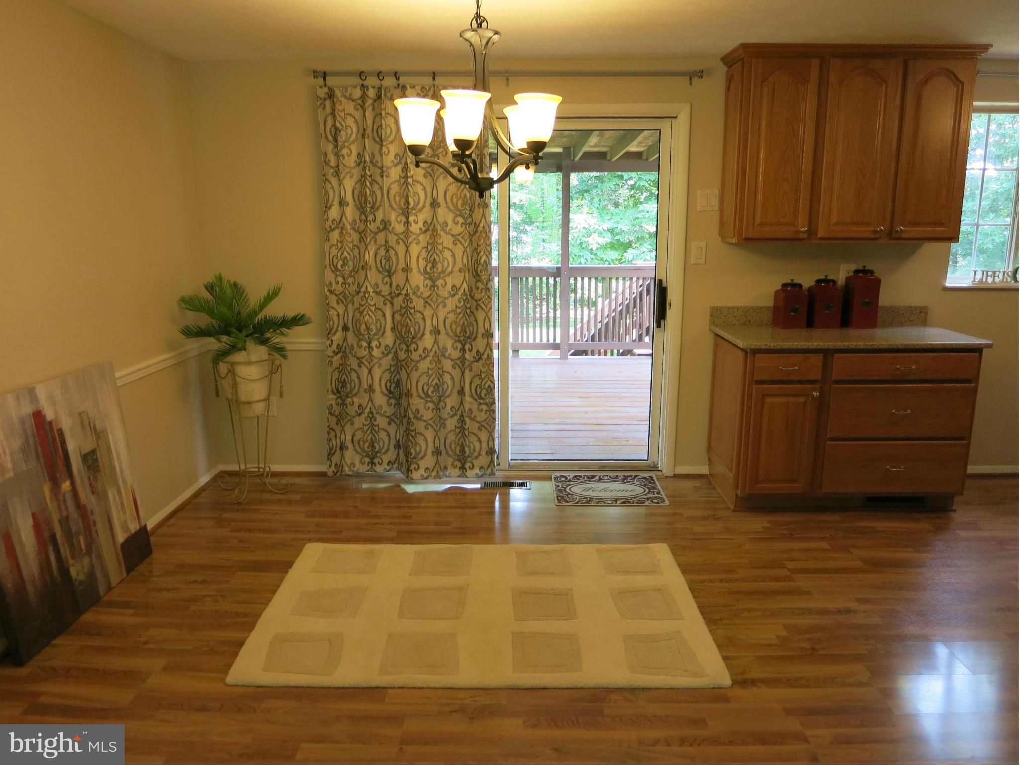 13705 Engleman Drive Laurel, MD 20708 - Photo 8 of 30 a room with a door open to a room with kitchen island granite countertop wooden floor and a window