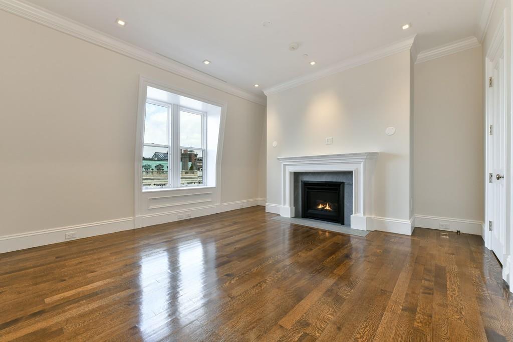 175 Beacon Street Boston, MA 02116 - Photo 25 of 35 an empty room with wooden floor fireplace and windows