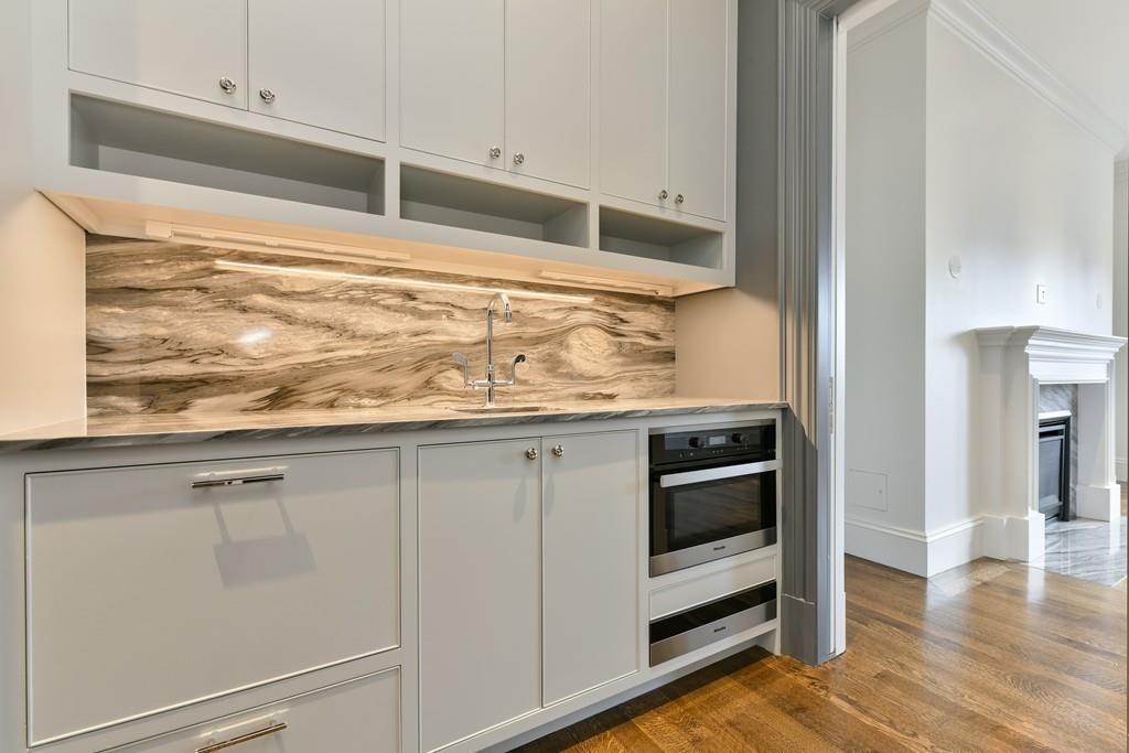 175 Beacon Street Boston, MA 02116 - Photo 28 of 35 a kitchen with granite countertop white cabinets and stainless steel appliances