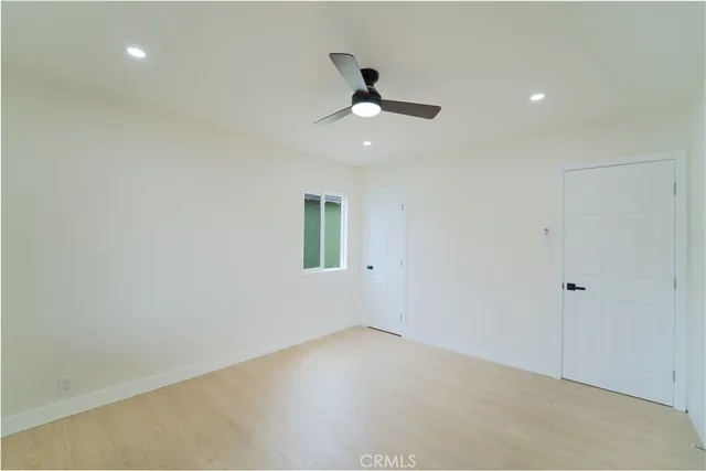 an empty room with a window and a ceiling fan