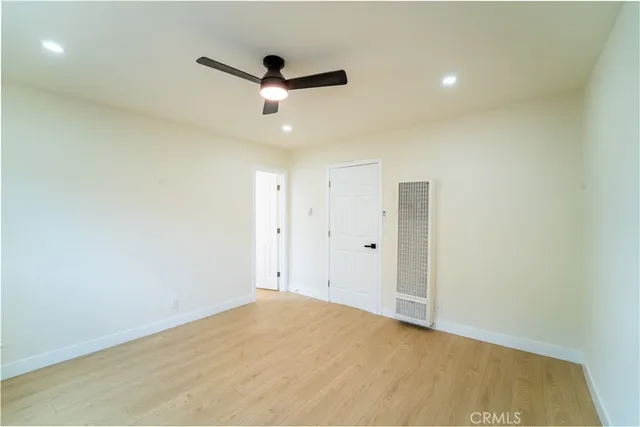 an empty room with ceiling fan and window