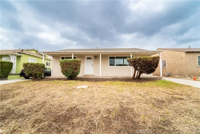 a view of a house with backyard and a garden