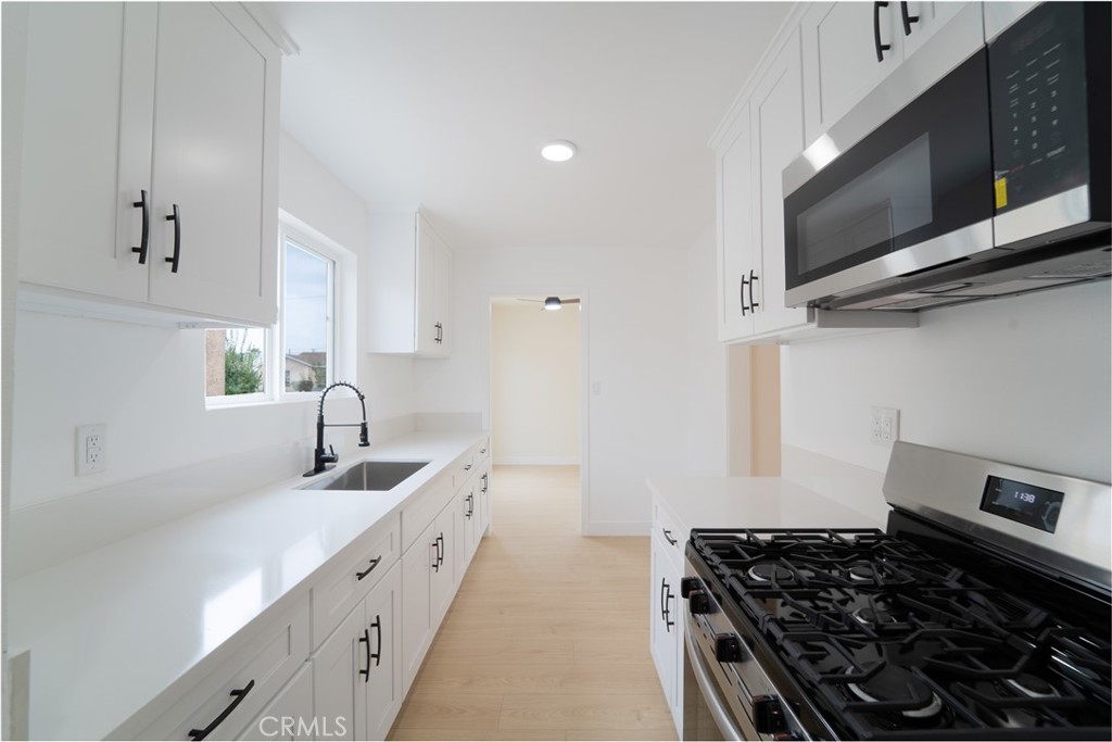 2204 West 153rd Street Compton, CA 90220 - Photo 8 of 21 a kitchen with stainless steel appliances a sink stove and microwave