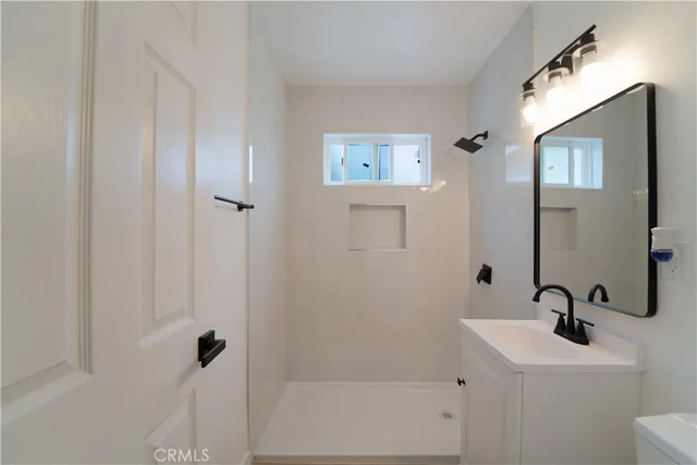 an empty room with a window and a ceiling fan