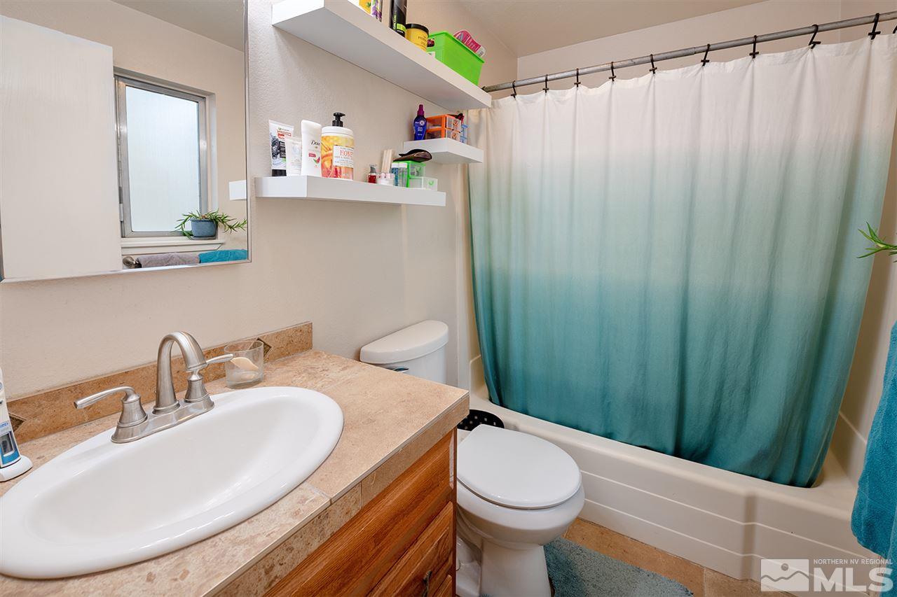 304 River Boat Road Dayton, NV 89403 - Photo 11 of 20 a bathroom with a sink a toilet and shower curtain