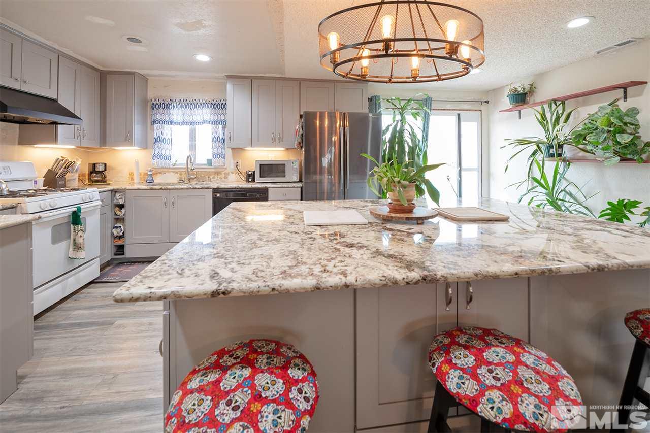 304 River Boat Road Dayton, NV 89403 - Photo 5 of 20 a kitchen with stainless steel appliances granite countertop a stove a sink and a dining table with wooden floors