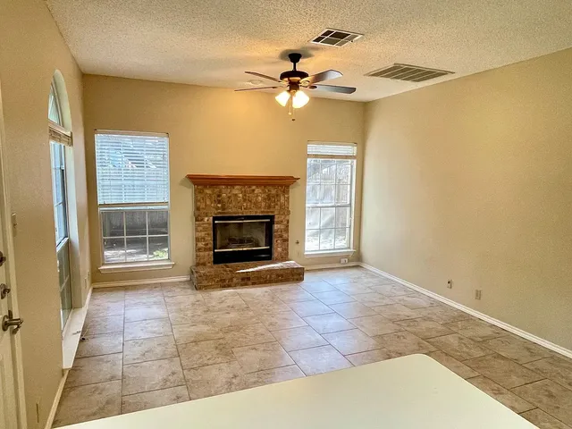 a view of a livingroom with a fireplace and a ceiling fan