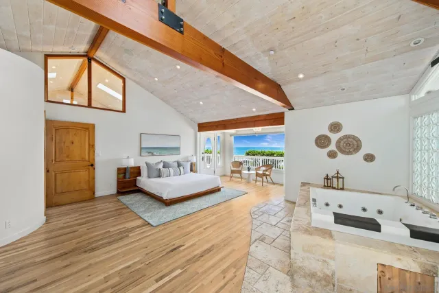 a bedroom with a bed and a dresser with wooden floor