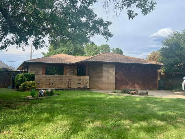 a front view of a house with a garden and trees