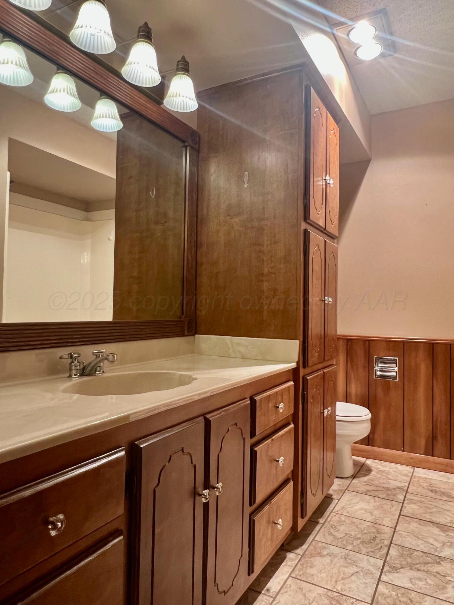 1402 Ave K Northwest Childress, TX 79201 - Photo 15 of 34 a bathroom with a sink a toilet and a mirror