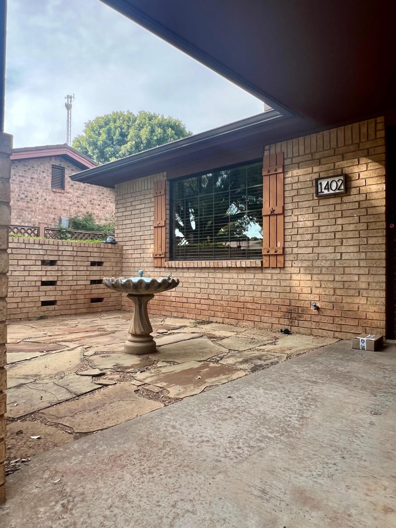 1402 Ave K Northwest Childress, TX 79201 - Photo 2 of 34 a view of a terrace with a chair and potted plants