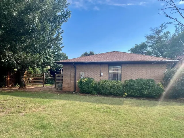 a view of a house with backyard and tree