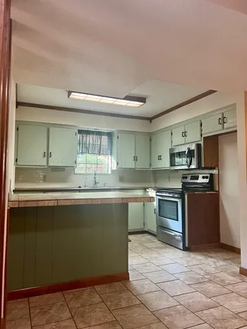 a kitchen with stainless steel appliances granite countertop a sink and cabinets