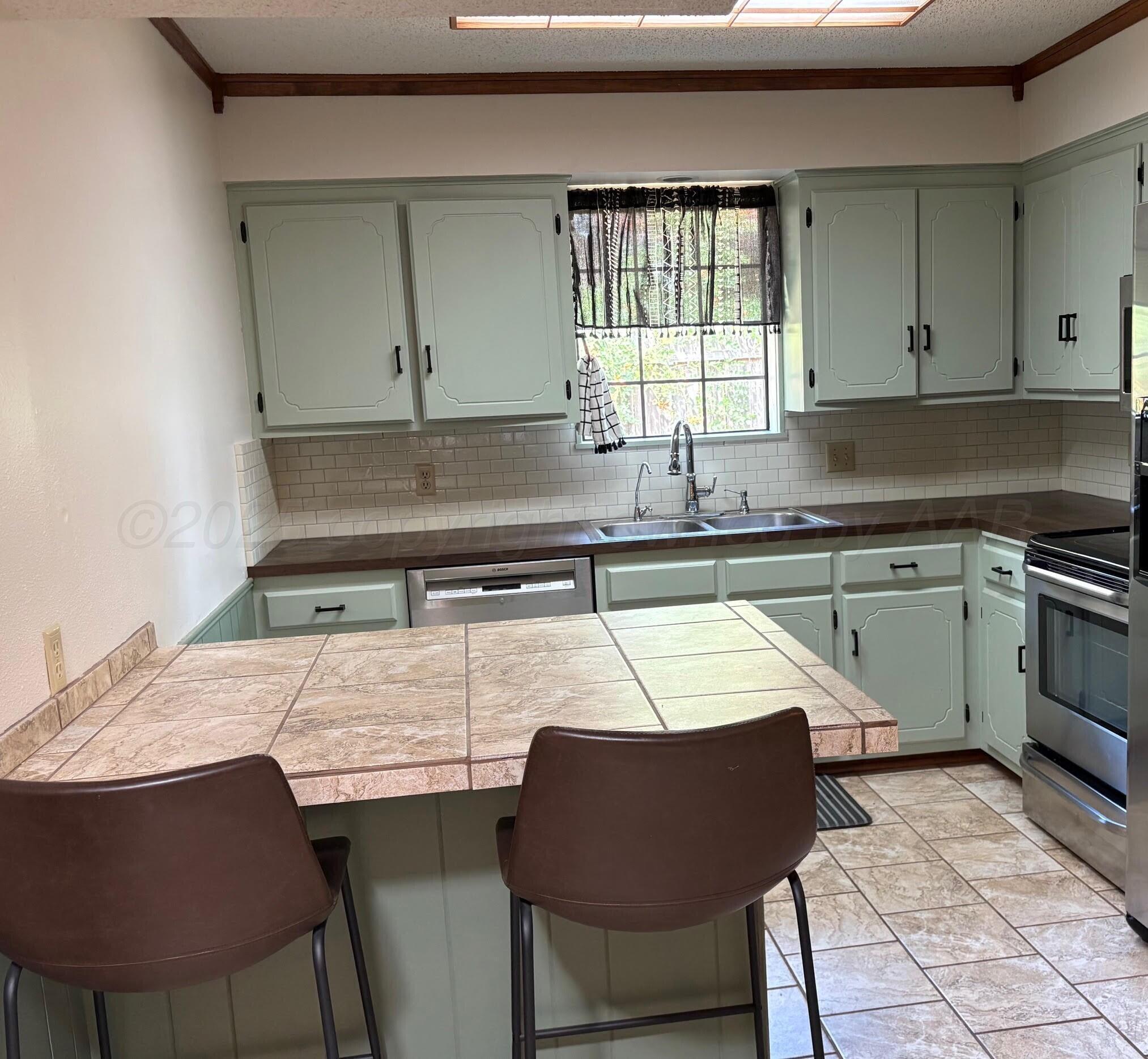 1402 Ave K Northwest Childress, TX 79201 - Photo 6 of 34 a kitchen with a table chairs sink and cabinets