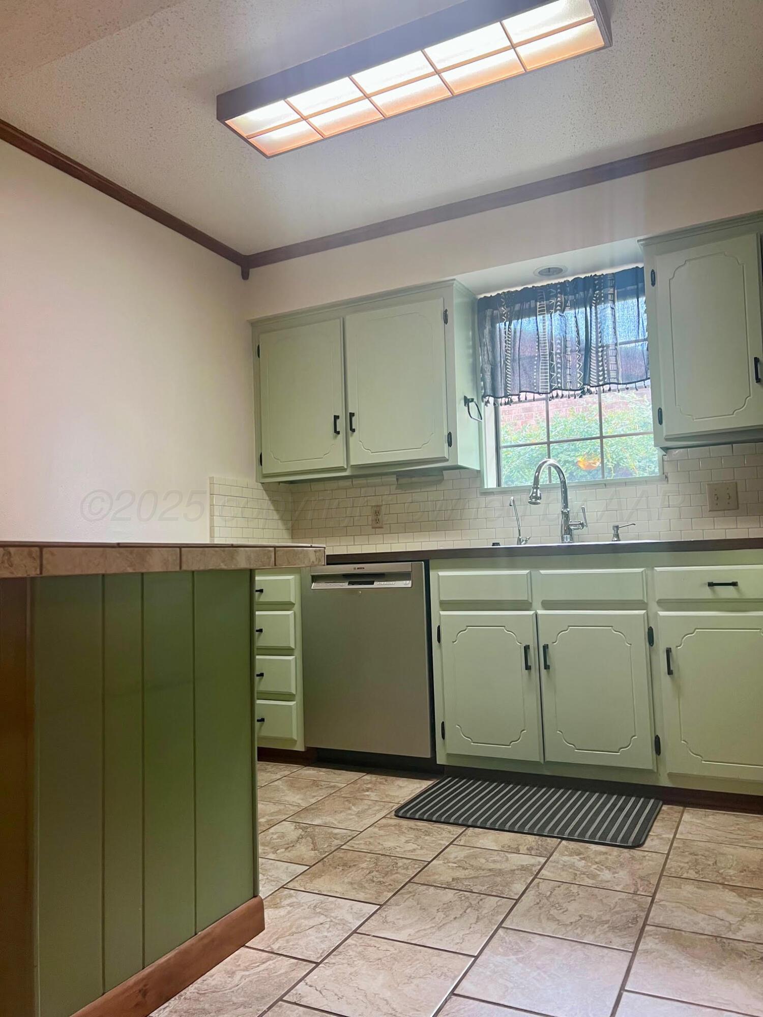 1402 Ave K Northwest Childress, TX 79201 - Photo 8 of 34 a kitchen with a cabinets a sink and a window