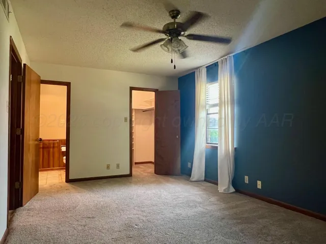 an empty room with chandelier fan