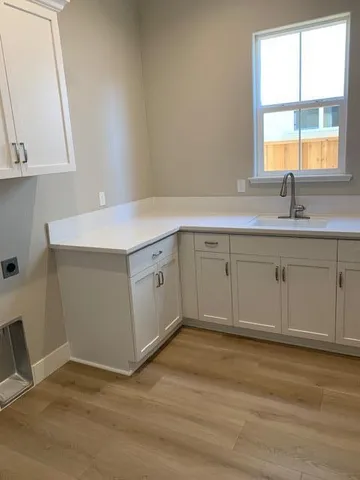 a view of a sink and dishwasher with wooden floor