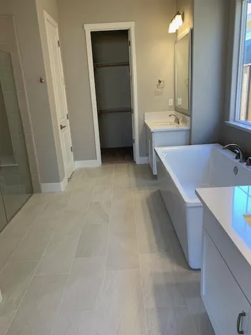 a bathroom with a tub sink and mirror