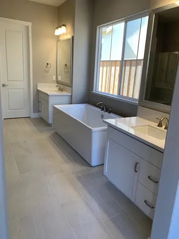 a spacious bathroom with a granite countertop tub sink and mirror