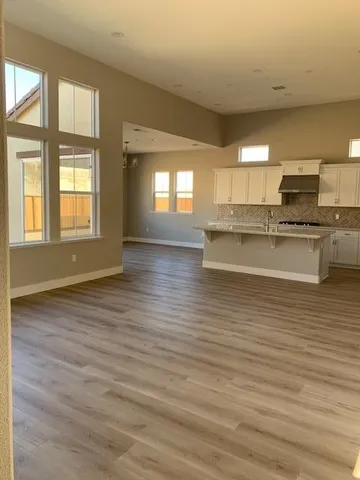 a room with stainless steel appliances wooden floor and a large window