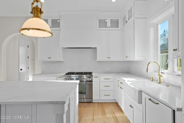 a kitchen with white cabinets appliances and a sink