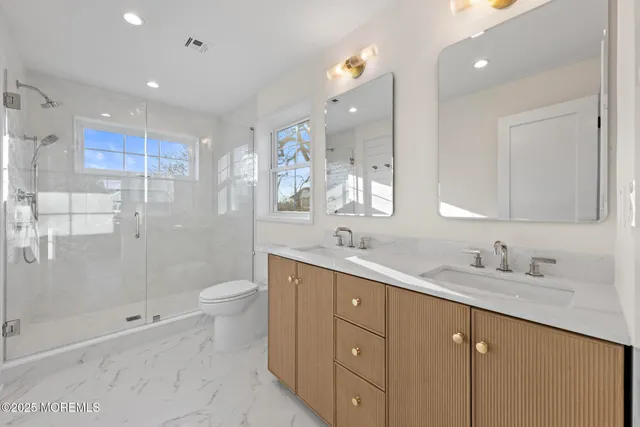 a bathroom with a sink a toilet and shower