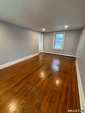 a view of empty room with wooden floor
