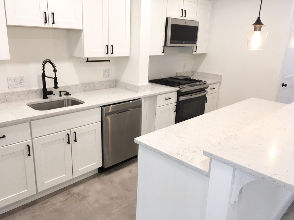 2239 Washington Street, Unit 200 Canton, MA 02021 - Photo 6 of 35 a kitchen with a sink and white cabinets