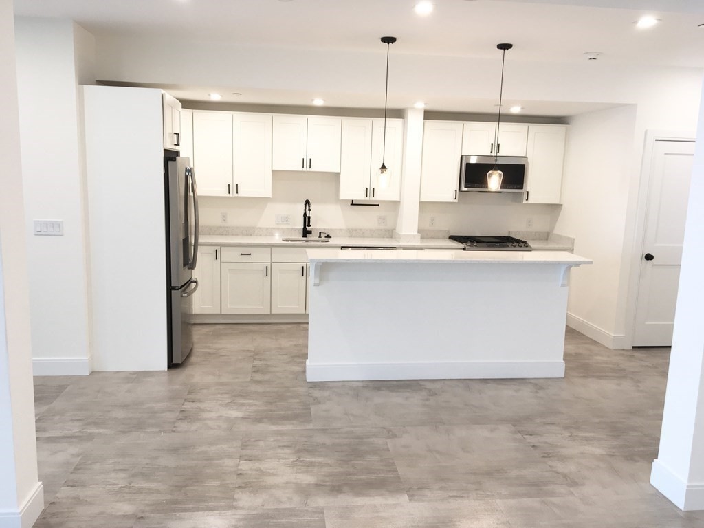 2239 Washington Street, Unit 200 Canton, MA 02021 - Photo 7 of 35 a kitchen with stainless steel appliances a refrigerator sink and cabinets