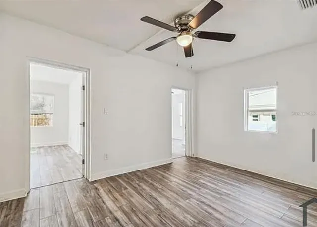 wooden floor in an empty room with a window