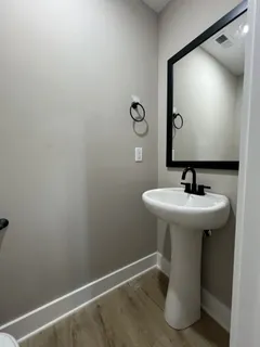 an empty room with chandelier fan and windows