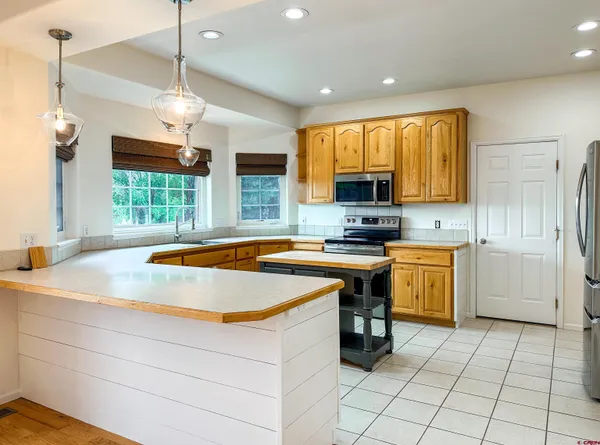 a kitchen with a stove a sink a refrigerator and a window