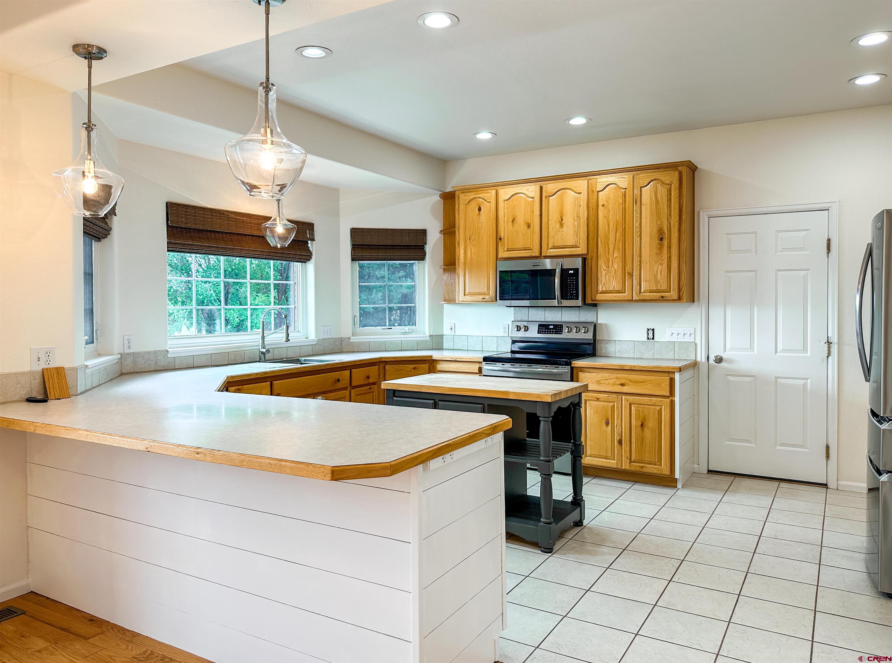 1484 1600th Road Delta, CO 81416 - Photo 17 of 45 a kitchen with a stove a sink a refrigerator and a window