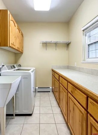 a utility room with cabinets washer and dryer