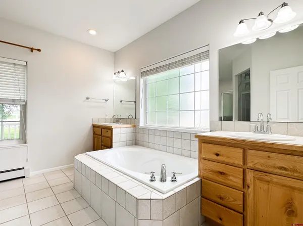 a bathroom with a tub sink and mirror